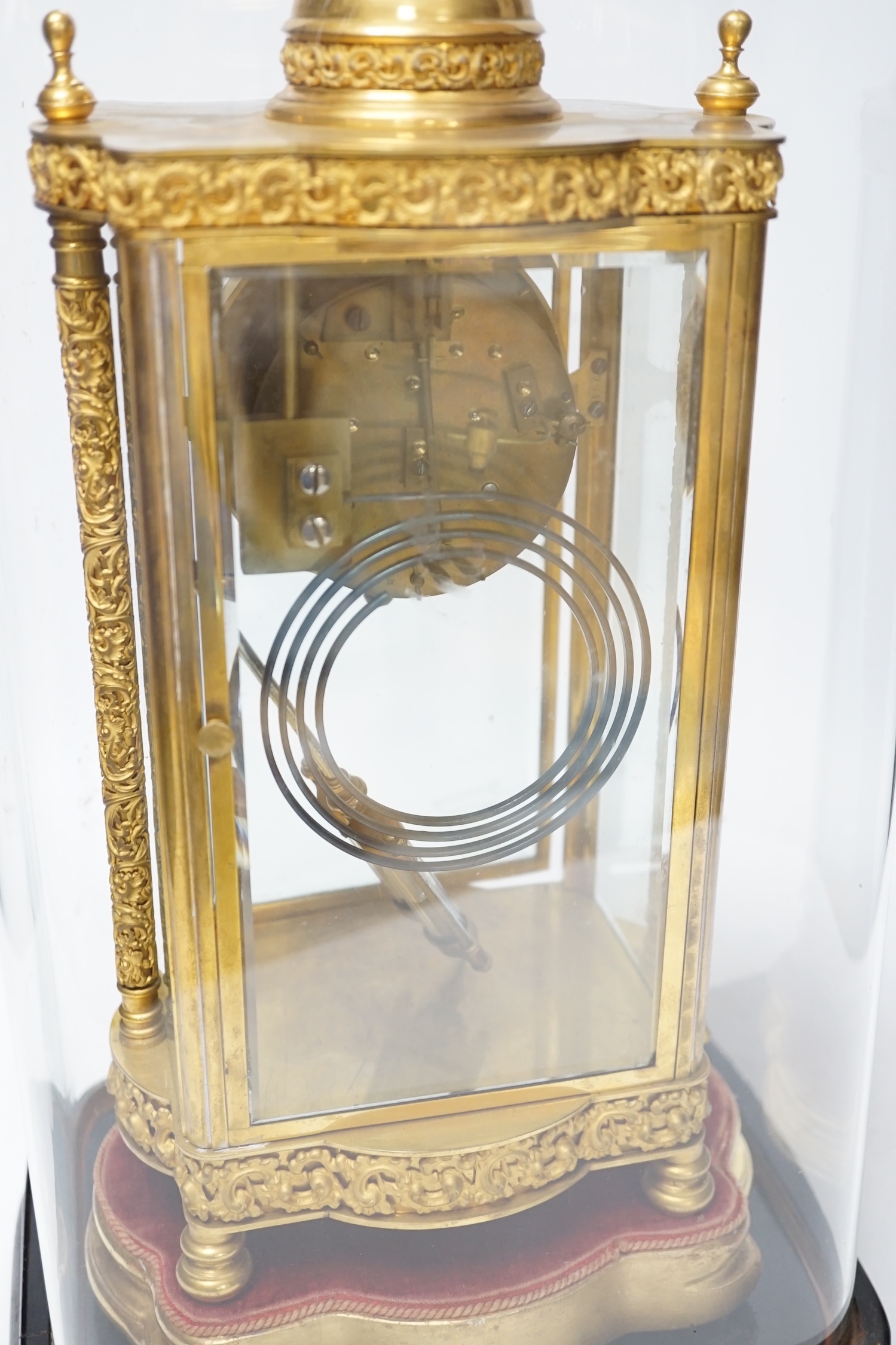 A French four glass mantel clock striking on a coiled gong with gilt brass frame and mercury pendulum, on a stand under a glass dome, 55cm high, with brass presentation label to stand dated December 1903